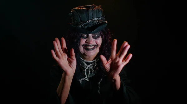 Skrämmande äldre kvinna med Halloween häxa makeup vågor hand handflata i hello hi gest välkomnar — Stockfoto