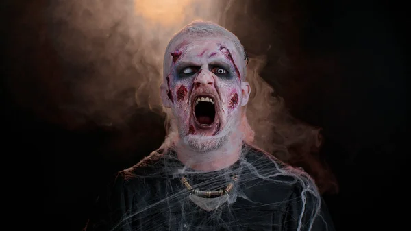 Homem assustador assustador com maquiagem ferida sangrenta de zumbi de  Halloween, tentando assustar, expressões faciais fotos, imagens de ©  efurorstudio #512336964