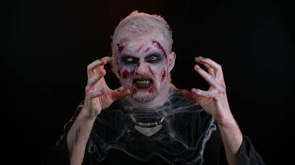 Hombre siniestro disfrazado de zombie loco de Halloween con cicatrices heridas sangrientas cara tratando de asustar —  Fotos de Stock