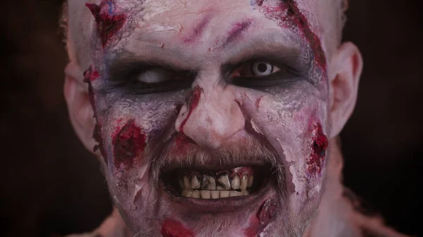 Strašidelný muž děsivé raněné krvavé jizvy tvář Halloween nemrtvý chlap fouká kouř z nosu, úsměvy — Stock fotografie