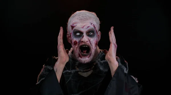 Aterrador hombre Halloween zombie levantando las manos en sorpresa mirando sorprendido por la victoria repentina —  Fotos de Stock