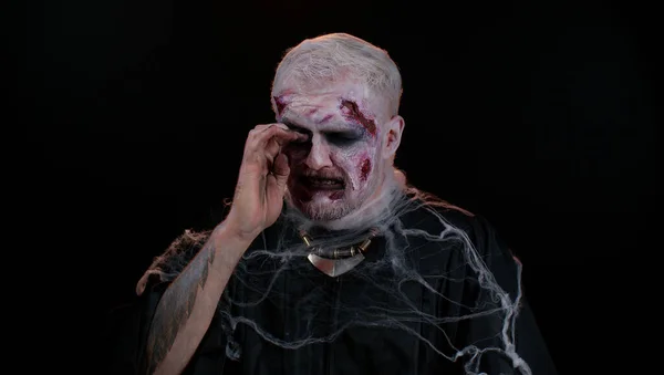 El hombre zombie perturbado de Halloween enjuga lágrimas y llora de desesperación, estando triste por cosas injustas — Foto de Stock