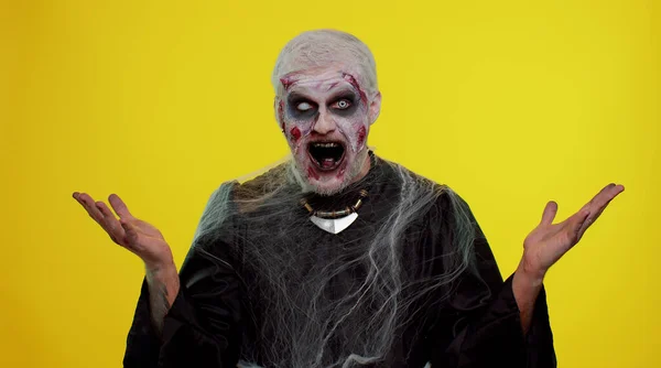 Gruseliger Mann Halloween-Zombie hebt überrascht die Hände und wirkt schockiert über plötzlichen Sieg — Stockfoto