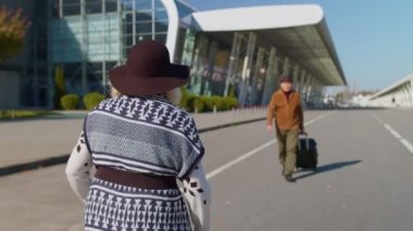Yaşlı karı-koca, turistlerin bir araya gelişi için havaalanı terminalinde toplandı.