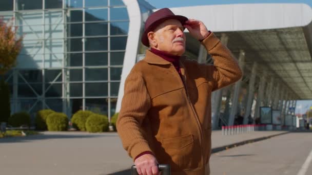 Портрет високопоставленого туриста-пенсіонера біля терміналу аеропорту очікування посадки на літак для подорожей — стокове відео
