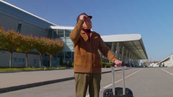 Portret starszego emeryta turysty w pobliżu terminalu lotniskowego czekającego na wejście na pokład samolotu do podróży — Wideo stockowe