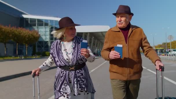 Esposo esposa jubilados turistas van a la terminal del aeropuerto para abordar con equipaje, billetes, pasaportes — Vídeos de Stock