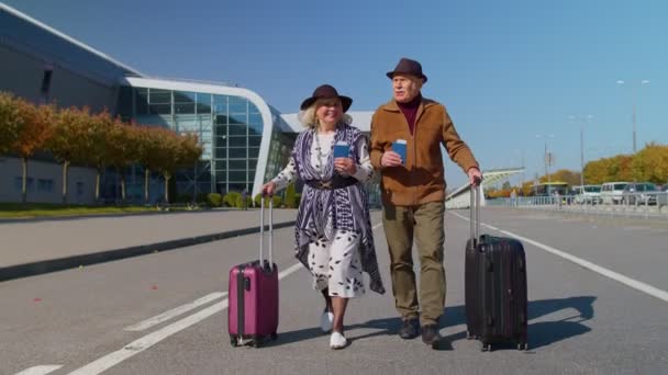 Stylish retired family couple granny grandfather walking with luggage suitcase bags to airport hall — Stock Video