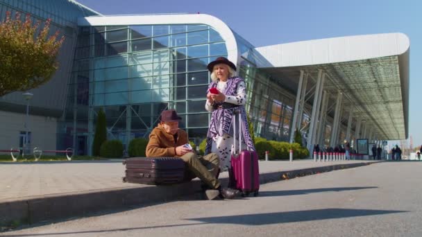 Nudí senioři manžel a manželka v důchodu turisté čekají na zpožděný nástup na letiště terminálu — Stock video