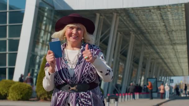Пожилая пенсионерка-туристка возле терминала аэропорта празднует успех, победу и достижение цели — стоковое видео