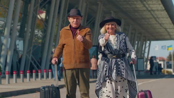 Senior pensionné touristes grand-mère grand-père lève les pouces réponse positive près de hall de l'aéroport — Video