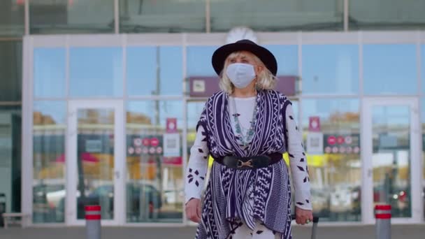 Старший пенсионер туристическая бабушка носить защитную маску для лица, избежать коронавируса рядом с аэропортом — стоковое видео