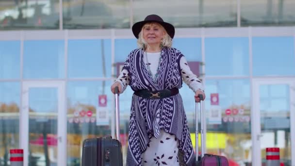 Nyugdíjas turista nagymama üzleti nő sétál a reptéri csarnok kapujában csomagtartóval — Stock videók