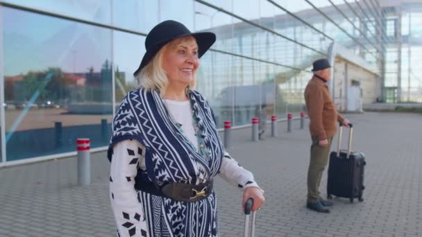 Senior pensionista turista abuela estancia cerca aeropuerto hall celebrar el éxito ganar gesto ganador — Vídeos de Stock