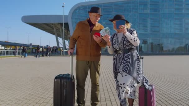 Senior ricos pensionistas turistas abuela abuelo estancia cerca aeropuerto sala celebrar dinero en efectivo dólar — Vídeos de Stock