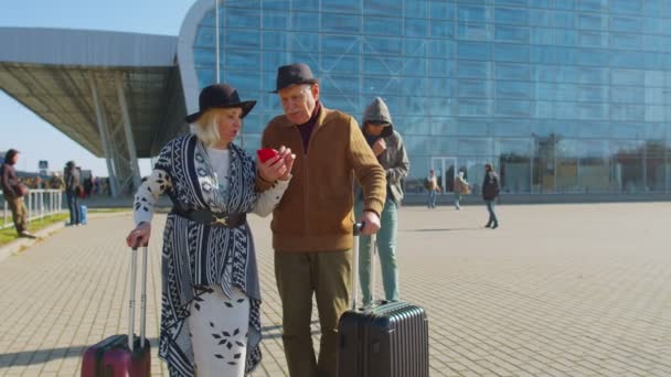 Вор крадёт деньги наличными из кармана пожилой пары туристов-пенсионеров возле аэропорта — стоковое видео