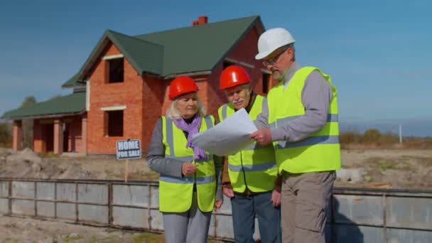 Uzmanlardan oluşan bir ekip modern ev gayrimenkul inşaatı projesini kıdemli inşaat mühendisiyle yürütüyor. — Stok video