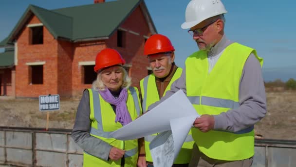 Agente inmobiliario vendiendo casa nueva al abuelo abuela mayor, mostrando planos de edificios — Vídeos de Stock