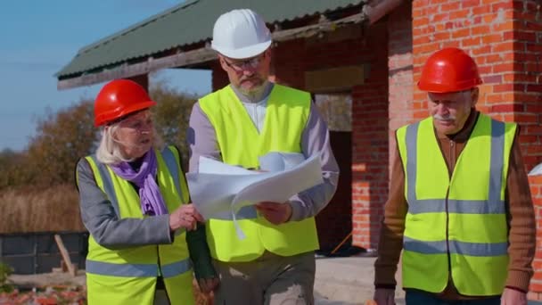 Architect met senior civiel ingenieurs bespreken projectwerk met blauwdruk van het gebouw huis — Stockvideo