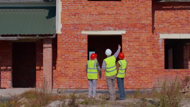 Equipo de especialistas que toman cerca de casa moderna proyecto de construcción de bienes raíces con ingeniero civil senior — Vídeo de stock