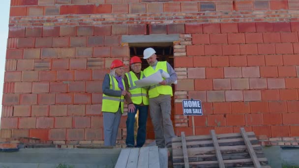 Агент з нерухомості, що продає новий будинок старшій бабусі, показує будівельні креслення — стокове відео