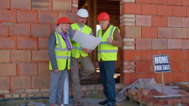 Agente inmobiliario vendiendo casa nueva al abuelo abuela mayor, mostrando planos de edificios — Vídeos de Stock