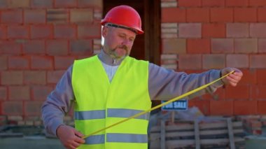 Pozitif inşaat mühendisi. Onaylayıcı bir şekilde kameraya bakıyor. Başparmak işareti gibi.