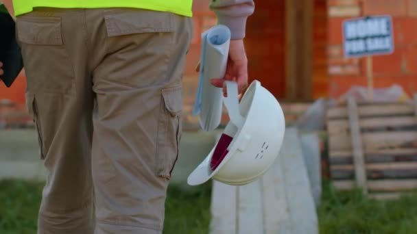 Arquiteto de projeto de construção de projetista imobiliário com capacete caminhando para canteiro de obras — Vídeo de Stock