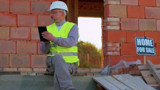 Bouwkundig ingenieur architect werkt met digitale tablet om werken op bouwplaats te controleren — Stockvideo