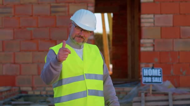 Positive builder engineer architect looking approvingly at camera showing thumbs up, like sign — Stock Video