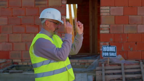 Architekt inženýr, který se na kameru dívá se zvednutými palci a doporučuje koupit dům — Stock video