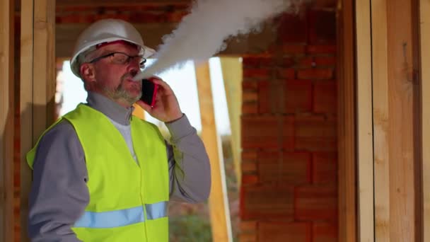 Professioneller Bauarchitekt telefoniert mit dem Handy, um die Arbeit auf der Baustelle zu kontrollieren