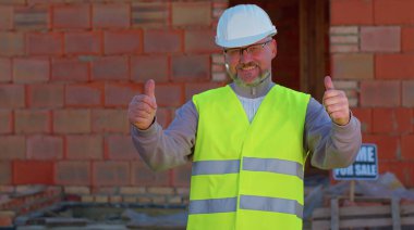 Mühendis mimar onaylayıcı bir şekilde kameraya bakıyor. Onaylıyor, ev almayı öneriyor.