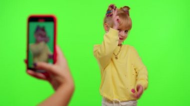 Mutlu funky blogger çocuk kız, sosyal ağ için akıllı telefondan komik dans videoları kaydediyor.