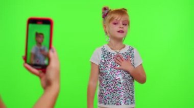Güzel küçük kız blogcu. Telefon kamerası önünde video kaydı. Chroma tuşunda dans içeriğinin keyfini çıkar.