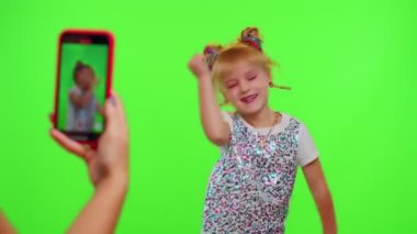 Mutlu funky blogger çocuk kız, sosyal ağ için akıllı telefondan komik dans videoları kaydediyor.