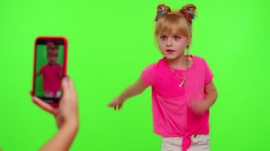 Mutlu küçük kız blogcu. Telefon kamerası önünde video kaydı. Krom anahtarda dans içeriğinin keyfini çıkar.