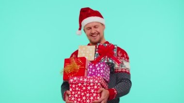 Noel süveteri içinde yakışıklı bir adam bir sürü hediye kutusu tutuyor. Yeni yıl hediye alışverişi.
