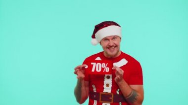 Kırmızı Noel tişörtlü adam hediye kutusu ve% 70 indirimli yazılar gösteriyor.