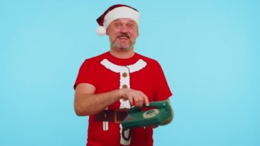 Noel tişörtlü komik bir adam 80 'lerin telli klasik telefonundan konuşuyor.