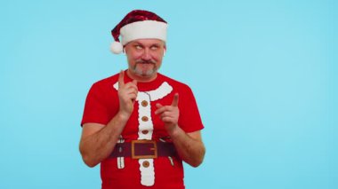 Noel tişörtlü bir adam kulaklıkla müzik dinliyor, disko dansı yapıyor, eğleniyor.