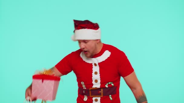 Muž v červeném vánočním tričku ukazuje dárkovou krabici a 50% sleva nápisy banner text poznámka — Stock video