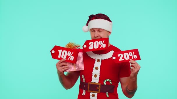 Человек в красной рождественской футболке с подарочной коробкой и скидочными надписями — стоковое видео