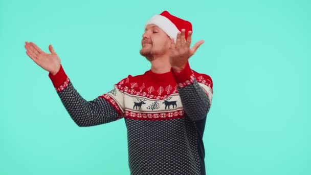 Homem de camisola de Natal enviando muitos beijos de ar olhando para a câmera e sorrindo, sentindo sua falta, amor — Vídeo de Stock