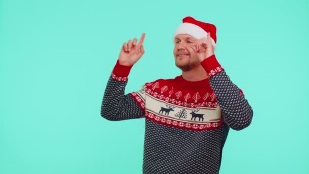 Hombre en jersey de Navidad escuchando música a través de auriculares, bailando discoteca divirtiéndose — Vídeo de stock