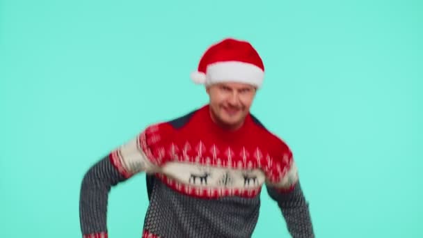 Crazy man in sweater Santa Christmas hat demonstrating tongue out, fooling around making silly faces — Stock Video