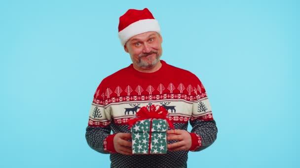 Komik adam kırmızı yeni yıl kazağı giyer ve şapka hediye paketini sunar, alışveriş indirimi tatilleri — Stok video
