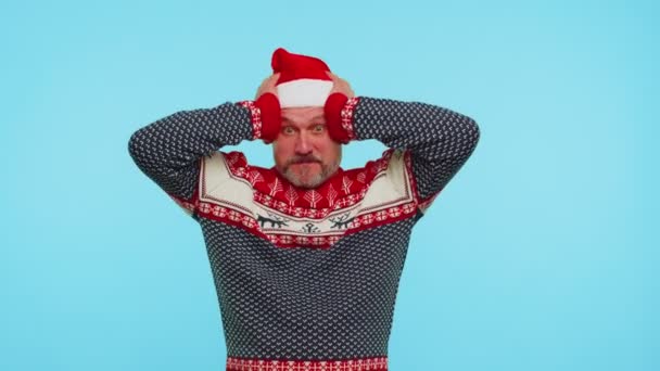Мужчина носит красный новогодний свитер оленя поднимая руки в удивлении шокирован внезапной победой, вау эмоции — стоковое видео
