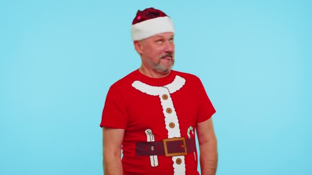 Noel Baba tişörtlü çılgın bir adam. Dilini gösteriyor, aptal suratlar yapıyor. — Stok video