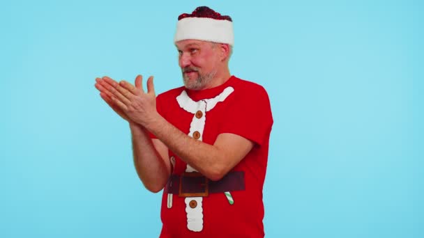 Чоловік у різдвяній футболці відправляє багато повітряних поцілунків, дивлячись на камеру і посміхаючись, зниклого вас, кохання — стокове відео